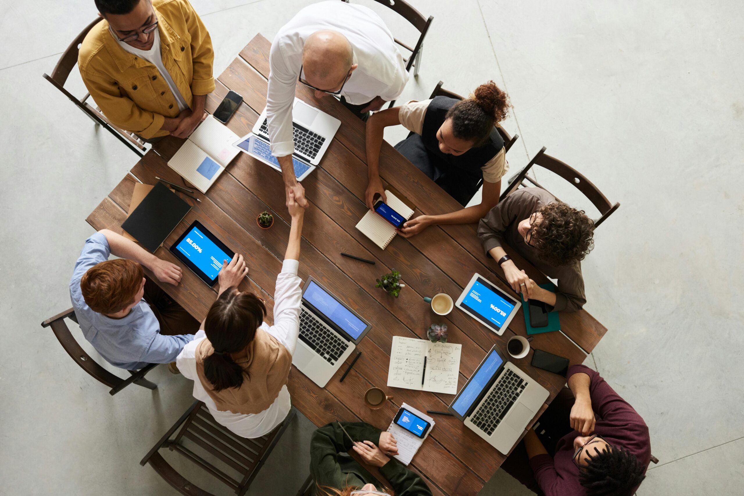 Group of work colleagues sitting around a wooden table, having a business meeting